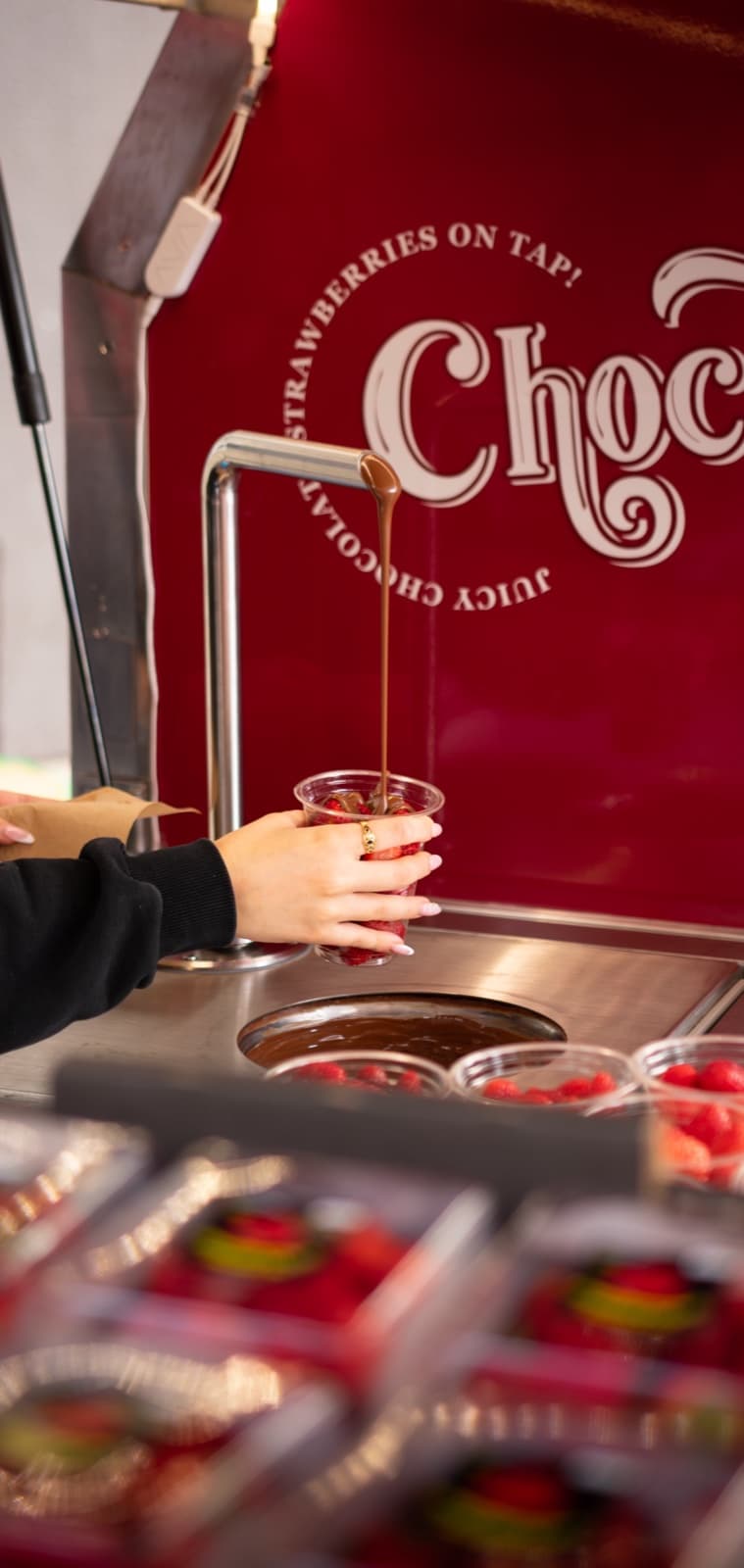 Chocolate being poured on tap over fresh Mt Barker strawberries
